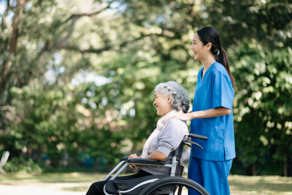 Elderly asian senior woman on wheelchair with Asian careful care