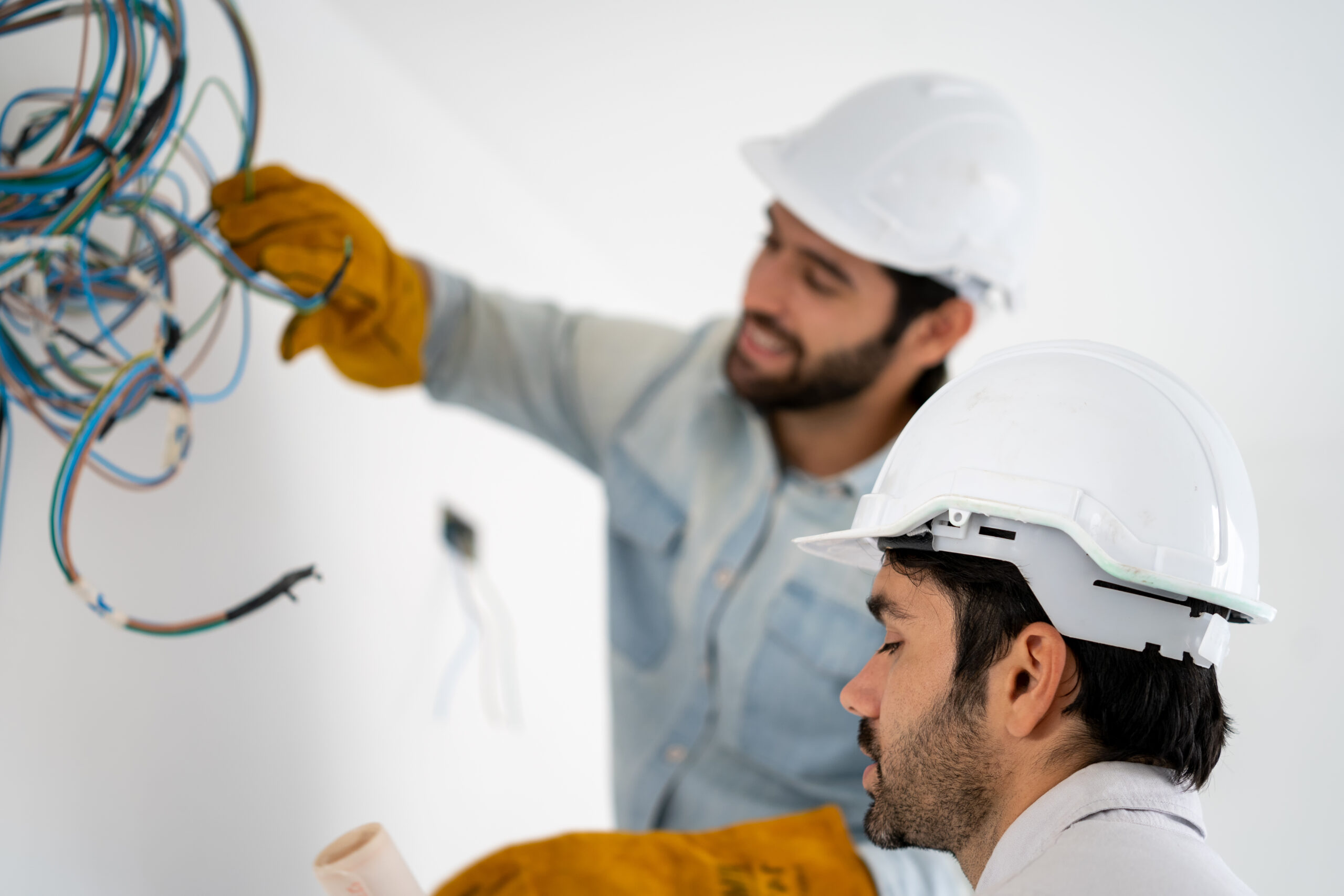 White card requirements - Electrician mounting wiring for electric sockets on the construction site of a new house, Construction concept. -