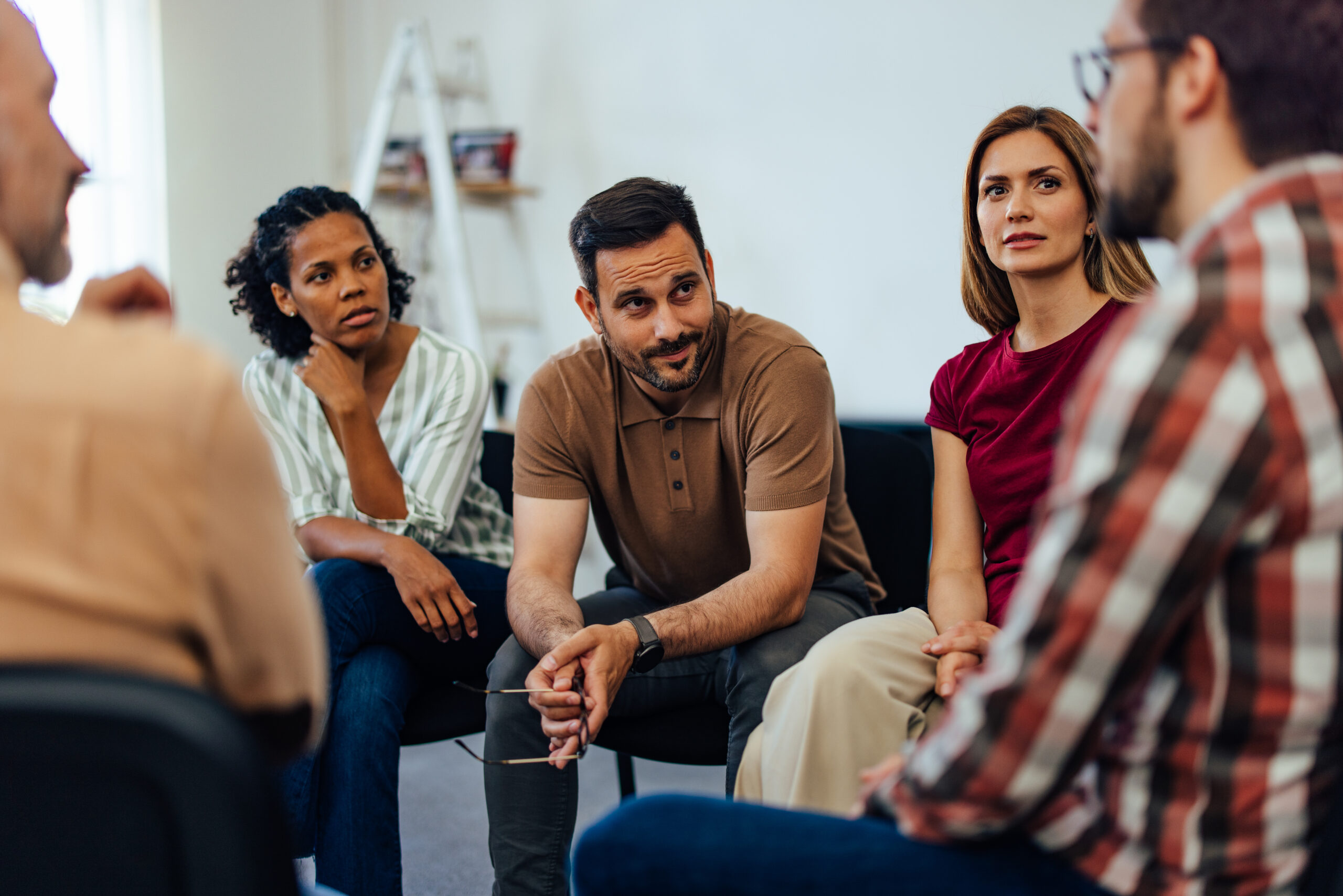 mental health support group - Diverse individuals engaging in a lively conversation within a welcoming and relaxed environment.